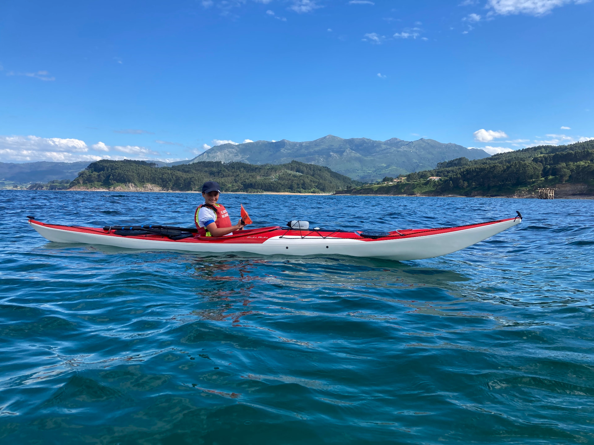 Kayak de mar frente a la costa y la montaña