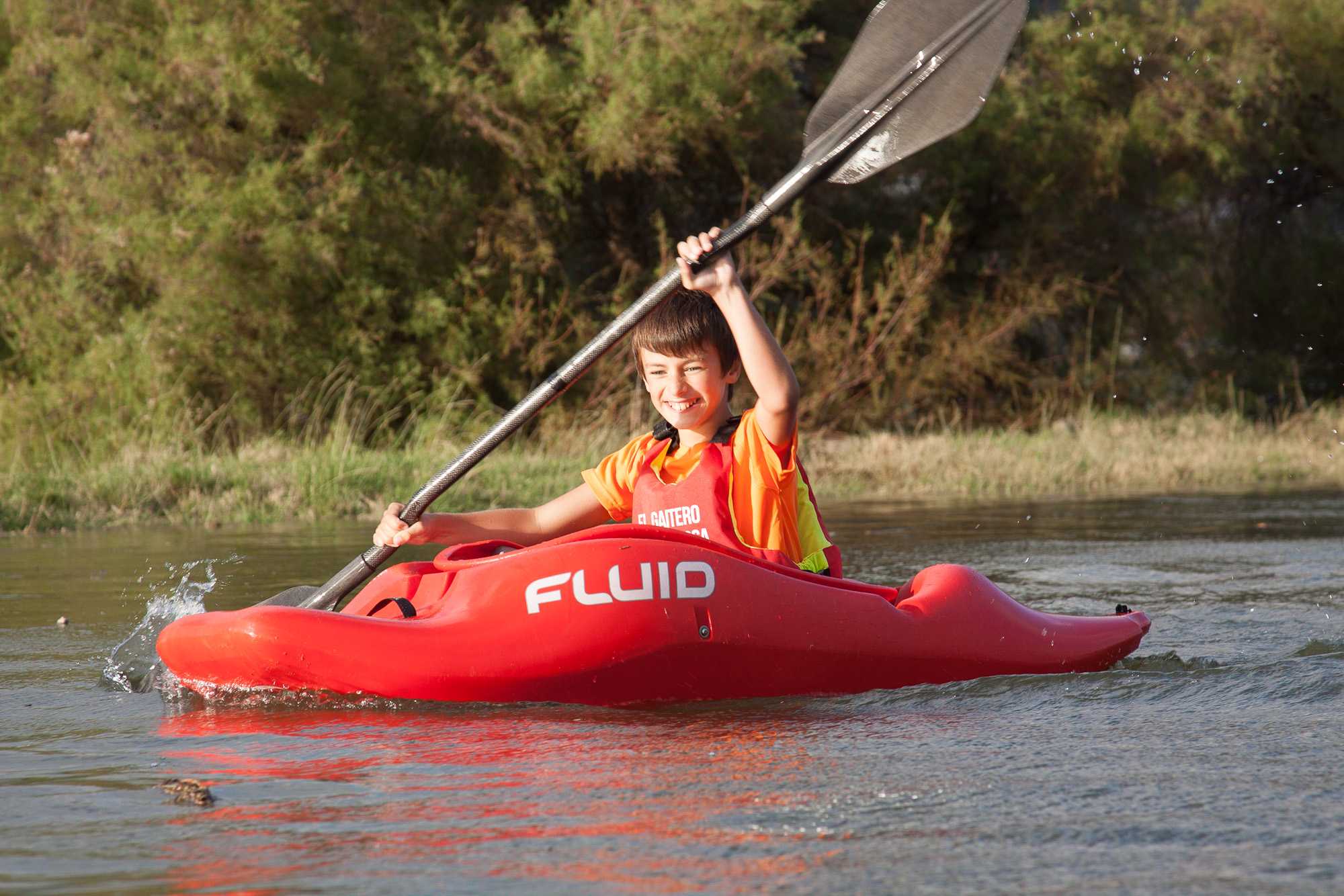 Mateo de niño en kayak rojo