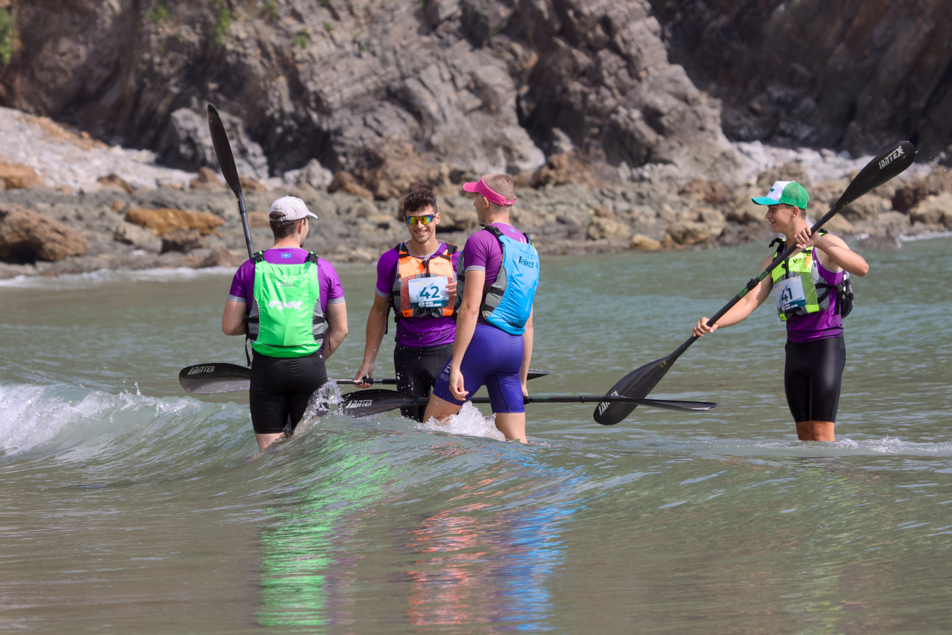 Palistas entrando al agua antes de una prueba de surfski